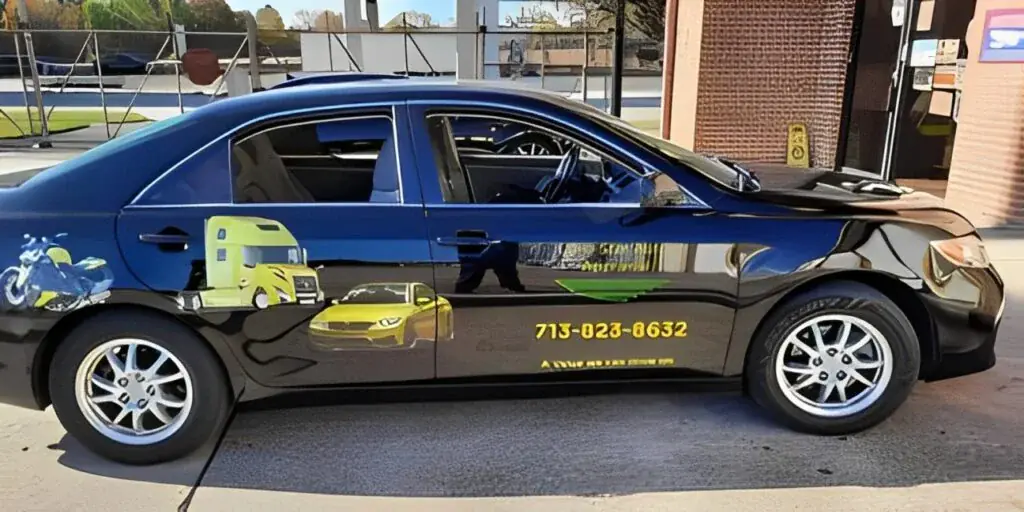 A car parked in front of a building with a yellow cab on the side.